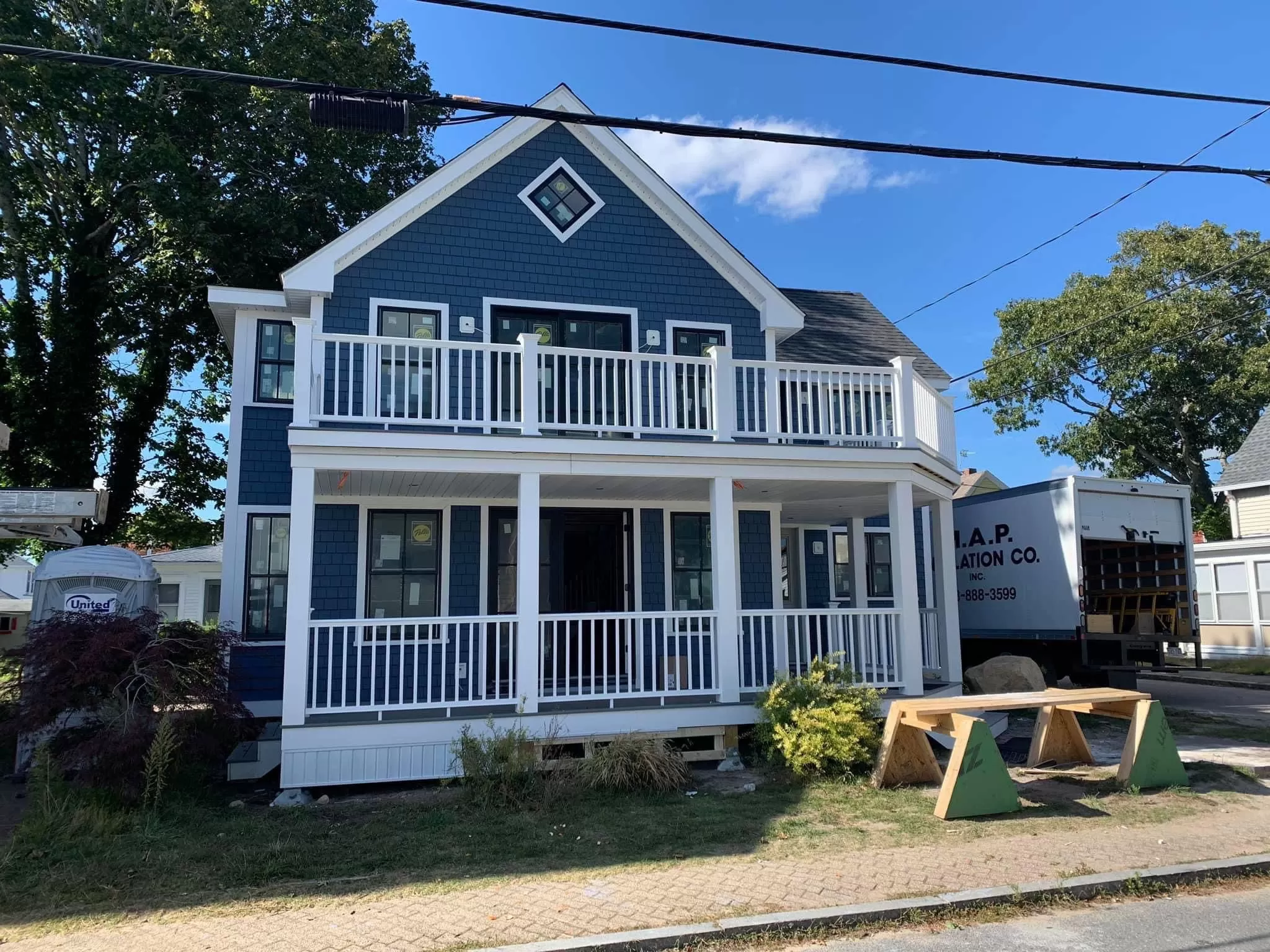 Blue-stained cedar shingle siding and front porch completed by Braun Construction in Centerville, MA