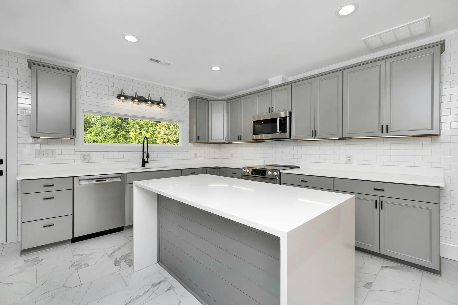 Kitchen with gray shaker cabinets finished in a smooth even coat, the result of professional cabinet painting