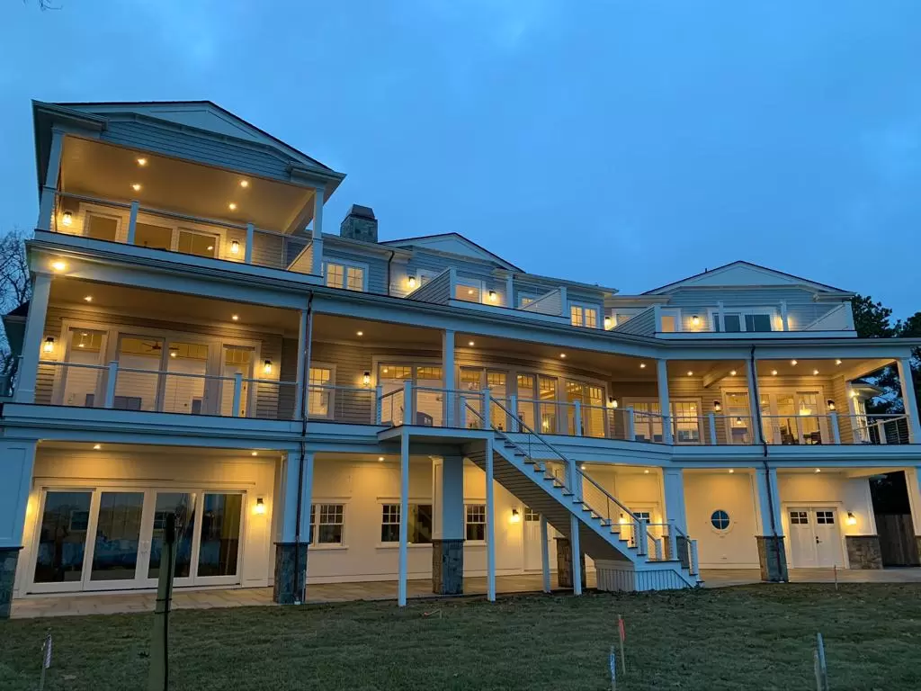 Custom waterfront home at dusk with new roof and cedar siding built by Braun Construction on Cape Cod