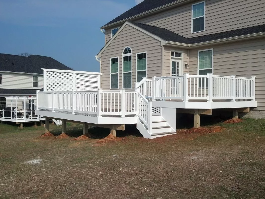 Elevated white vinyl deck with privacy lattice and staircase constructed by Braun Construction in Massachusetts